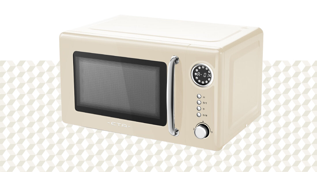 Beżowa kuchenka mikrofalowa z okrągłym wyświetlaczem i trzema przyciskami obok. Na drzwiczkach widoczne jest logo \'ETA\'.