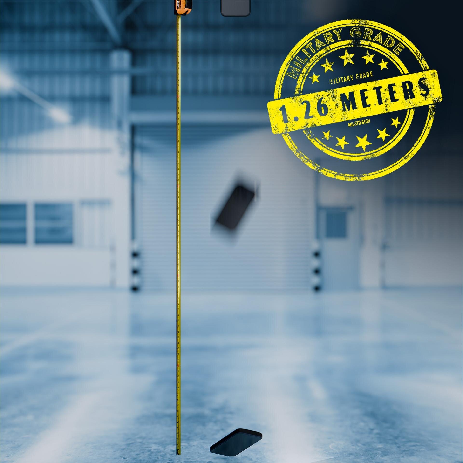 Obraz przedstawia telefon komórkowy w trakcie upadku na podłogę w dużym, jasnym pomieszczeniu. Na obrazie widoczny jest żółty znak z napisem \'MILITARY GRADE 1.26 METERS MIL-STD-810H\'.