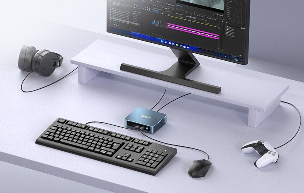 Komputer PELADN WI-6 N95 Miniaturowy komputer podłączony do monitora, klawiatury, myszki oraz kontrolera do gier na białym biurku w uporządkowanym stanowisku pracy