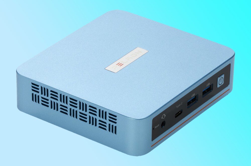 Komputer PELADN WI-6 Zbliżenie na przedni panel jasnoniebieskiego urządzenia, na którym znajdują się od lewej: przycisk reset, gniazdo słuchawkowe, port USB-C, dwa porty USB oraz podświetlany przycisk zasilania