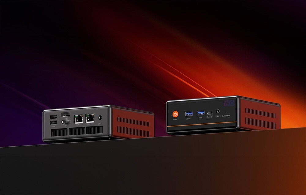 Komputer PELADN WO4 Dwa urządzenia elektroniczne widziane pod kątem na ciemnym tle z fioletowymi i pomarańczowymi smugami światła, ukazujące rozmieszczenie złączy USB, audio oraz gniazd zasilania i sieciowych