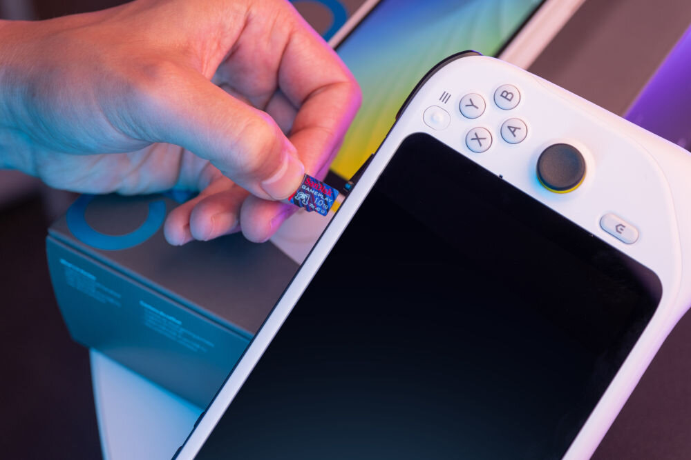 Karta pamięci SANDISK Gameplay MicroSDXC 1TB wkładanie karty do konsoli w tle pudełko dodatkowa przestrzeń na gry i aplikacje