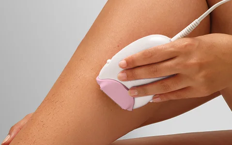 Zbliżenie nogi z depilatorem Braun Silk·épil 3 przykładanym do skóry.