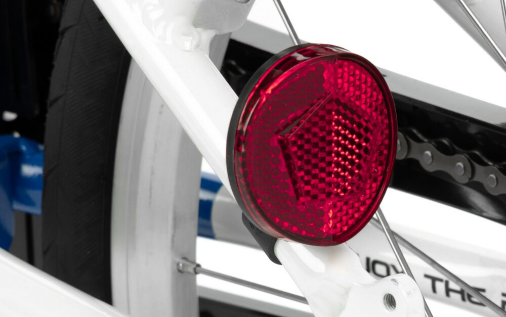 Rower dziecięcy KARBON Superlight 18 cali dla chłopca Niebieski białe tło zbliżenie na odblask umieszczony na pod siodełkiem pakiet odblasków umieszczonych w kluczowych miejscach konstrukcji rowerek staje się lepiej widoczny po zmroku i w pochmurne dni wsparcie bezpieczeństwa odblaski zwiększają dostrzegalność dziecka