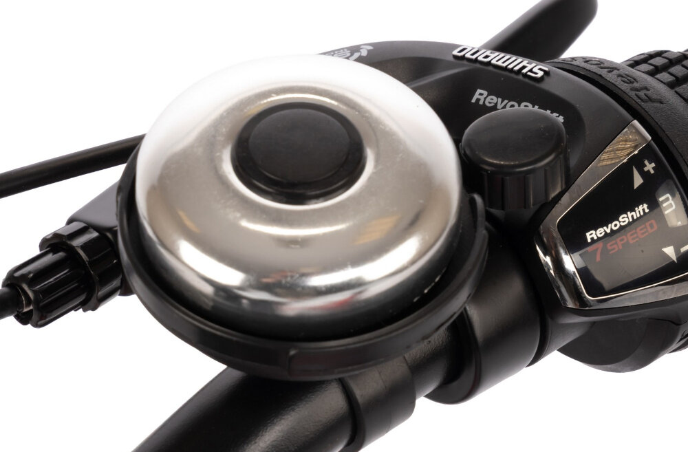 Rower dziecięcy KARBON Superlight 20 cali dla chłopca Czerwony białe tło zbliżenie na dzwonek praktyczny dzwonek sygnalizowanie obecności element zwiększający bezpieczeństwo