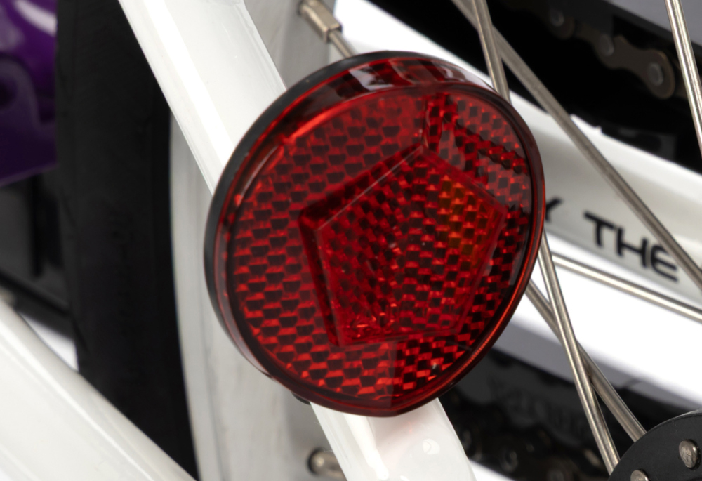 Rower dziecięcy KARBON Superlight Automatic 18 cali dla chłopca Fioletowy białe tło zbliżenie na odblask umieszczony na ramie pod siodełkiem pakiet odblasków umieszczonych w kluczowych miejscach konstrukcji rowerek staje się lepiej widoczny po zmroku i w pochmurne dni wsparcie bezpieczeństwa odblaski zwiększają dostrzegalność dziecka