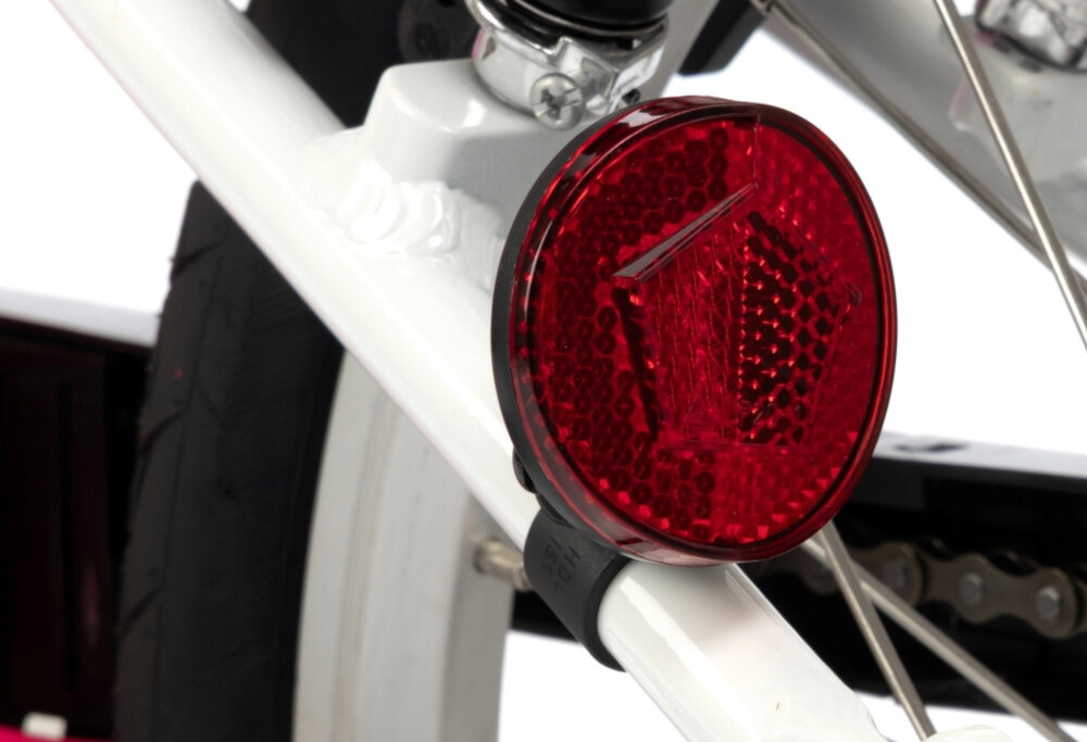 Rower dziecięcy KARBON Superlight Automatic 18 cali dla dziewczynki Różowy białe tło zbliżenie na odblask umieszczony na ramie pod siodełkiem pakiet odblasków umieszczonych w kluczowych miejscach konstrukcji rowerek staje się lepiej widoczny po zmroku i w pochmurne dni wsparcie bezpieczeństwa odblaski zwiększają dostrzegalność dziecka