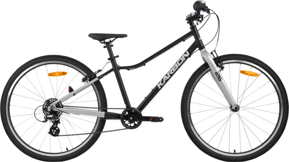 Rower młodzieżowy KARBON Superlight 26 cale dla chłopca Czarny rower na białym tle widoczny od przodu pod skosem dla dzieci w wieku od 8 do 11 lat lekka konstrukcja (waga 9 kg) ułatwia dziecku manewrowanie i kontrolowanie roweru odpowiednio dobrane komponenty ergonomiczna geometria stabilność i bezpieczeństwo rozwój równowagi, koordynacji i pewności siebie dziecka