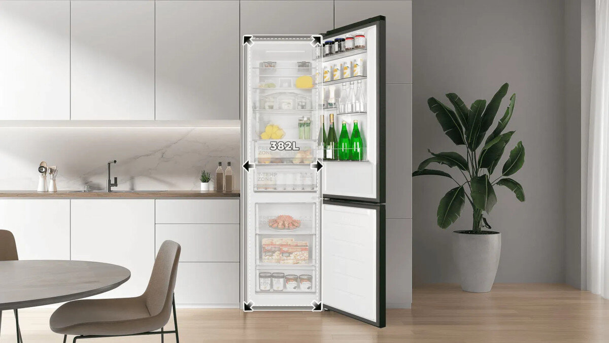 LODÓWKA TCL RC382BXC0EU W jasnej kuchni otwarta lodówka prezentuje starannie ułożone produkty na półkach. Wnętrze jest jasne i pojemne, podkreślając dużą wydajność urządzenia funkcjonalne wnętrze lodówki szuflady balkoniki przestronne półki wygoda korzystania