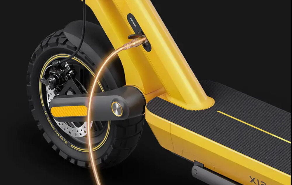 Hulajnoga elektryczna XIAOMI Electric Scooter 6 Ultra 75km 500W 2 Amortyzatory 12 cali Żółty ciemne tło zbliżenie na koło przewód w gniazdku do ładowania zasięg do 75 km stabilna praca układu napędowego wydajna bateria litowo-jonowa o pojemności 12,5 Ah i napięciu 46,8 V czas ładowania około 10,5 godziny