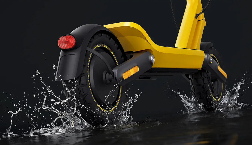 Hulajnoga elektryczna XIAOMI Electric Scooter 6 Ultra 75km 500W 2 Amortyzatory 12 cali Żółty ciemne tło hulajnoga widoczna od tyłu rozchlapana woda klasa ochrony IPX5 odporność obudowy na wodę, pył, brud i przypadkowe zachlapania chroni elektronikę przed drobnymi zabrudzeniami oraz wilgocią