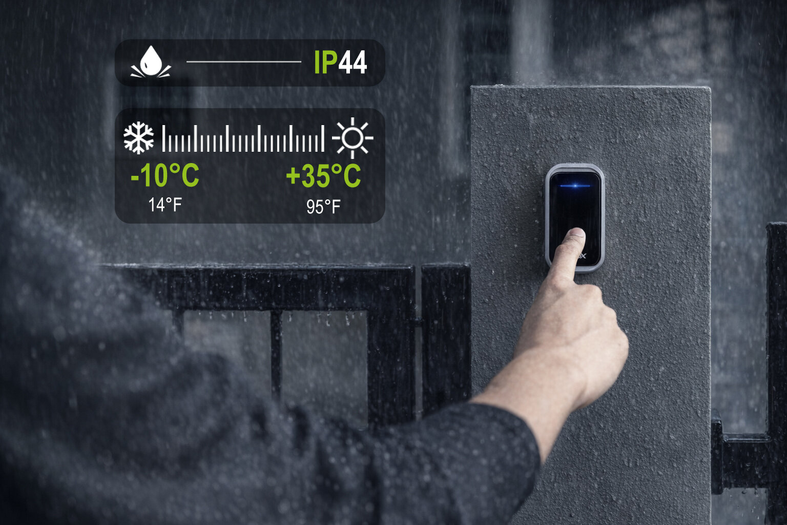 Osoba naciska przycisk na czarnym dzwonku do drzwi zamontowanym na betonowym słupku w deszczu. Na obrazie widoczne są oznaczenia IP44 oraz zakres temperatur od -10°C do +35°C (14°F do 95°F).