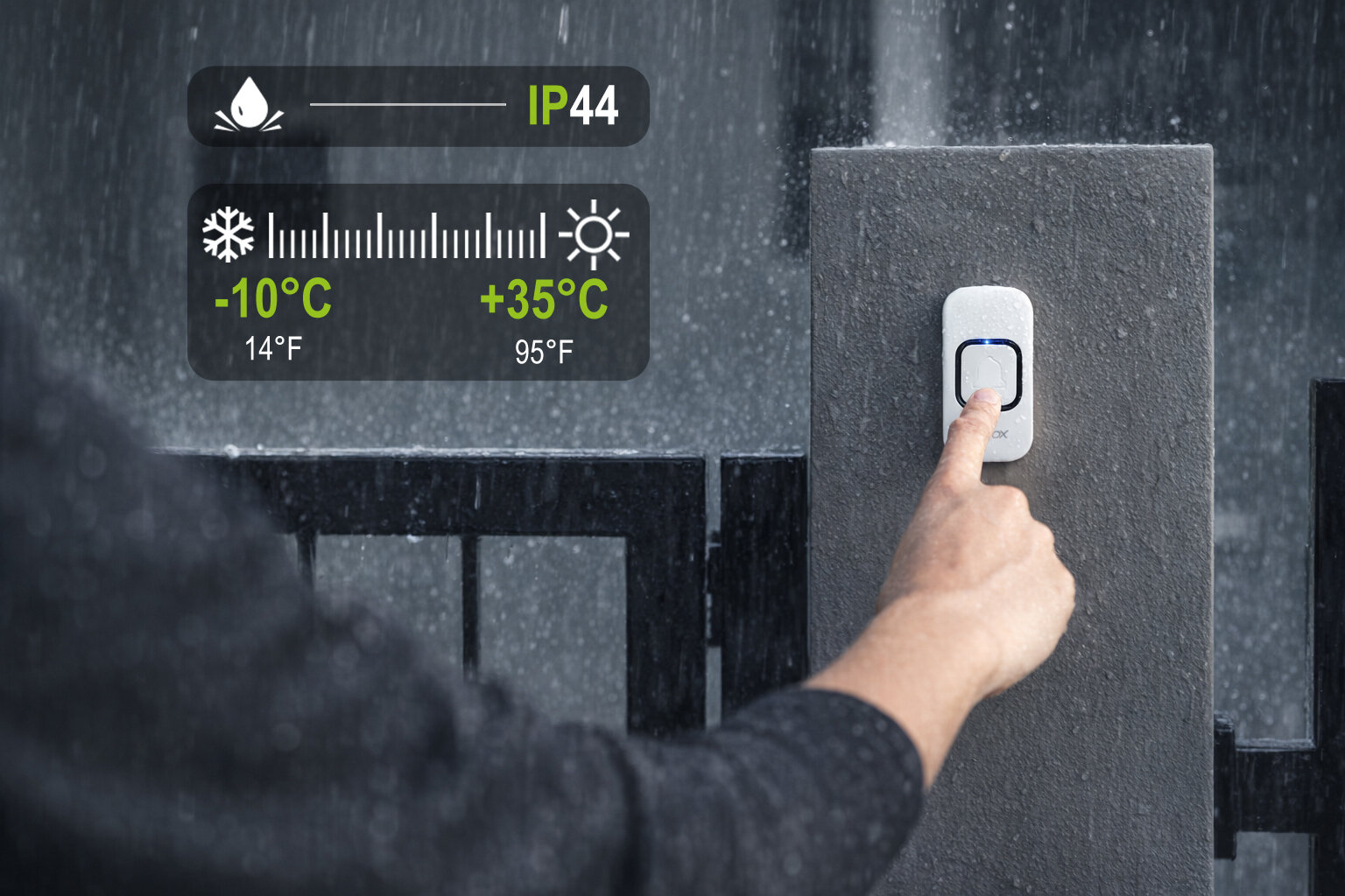 Osoba naciska biały, bezprzewodowy dzwonek do drzwi zamontowany na słupku w deszczu. Widoczne są oznaczenia IP44 oraz zakres temperatur od -10°C do +35°C.