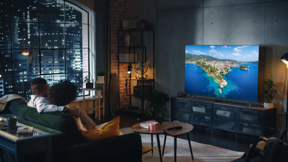 Telewizor KIANO Elegance 55 multimedia dostępne HDMI USB WiFi, telewizor stojący na komodzie w pomieszczeniu, osoby oglądające film