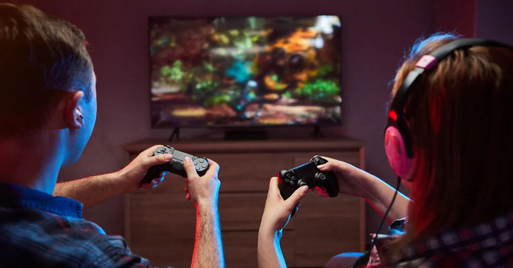 Telewizor KIANO Elegance 55 jasny ekran słońce szczegóły, telewizor na komodzie, osoby trzymające kontroler w ręku