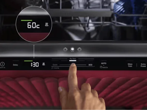 Panel sterowania zmywarki z wyświetlaczem pokazującym temperaturę 60°C i czas 1:30. Widoczny jest palec wskazujący na przyciskach z opcjami takimi jak Quick, ECO, AUTO, Glass Care, Extra Power.