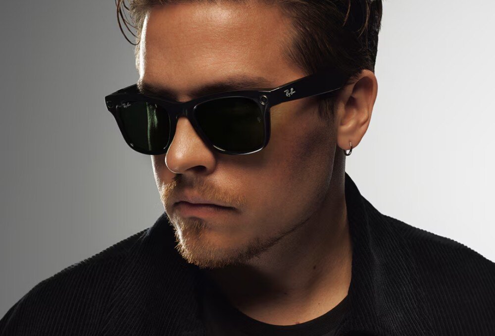 Okulary META Ray-Ban Wayfarer Gen 2 czarne okulary przeciwsłoneczne z ciemnymi szkłami, ułożone pod skosem na białej powierzchni, eksponujące połyskliwą oprawkę i wbudowane elementy optyczne