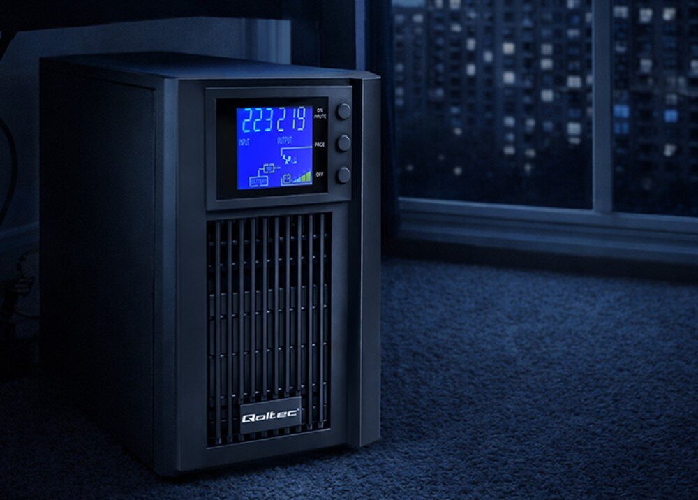 Na obrazie widoczny jest zasilacz UPS z wyświetlaczem LCD pokazującym wartości \'223219\'. Na obudowie znajduje się logo \'Qoltec\'.