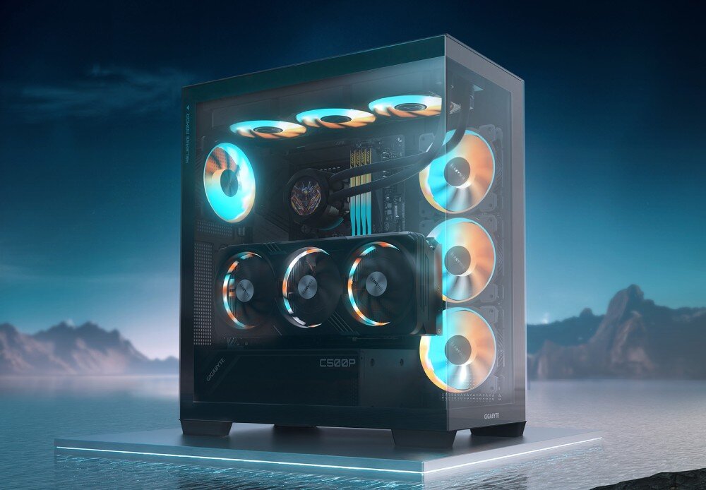 Komputer MAD DOG GeForce RTX5090 DLSS 4 Reflex Edition 2 Powered by Gigabyte C500-A06WR64WH Komputer stacjonarny z przezroczystą boczną szybą, w której widać podświetlane wentylatory i kartę graficzną, ustawiony na platformie z krajobrazem gór i jeziora w tle, przeznaczenie, zalety, testy