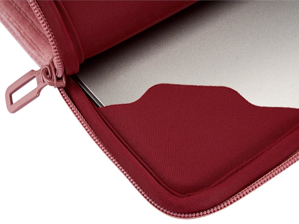 Różowe etui na laptopa z zamkiem błyskawicznym, wewnątrz którego znajduje się srebrny laptop. Materiał etui jest miękki i wyściełany.