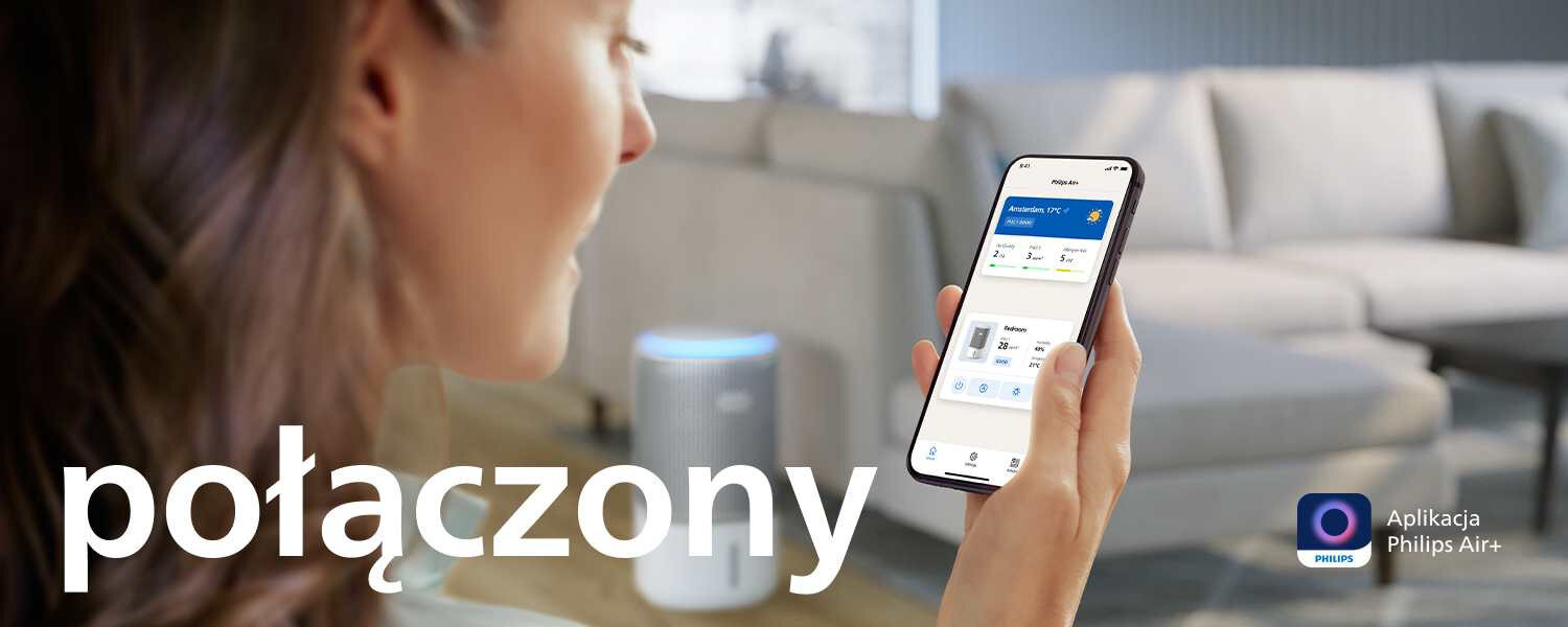 Osoba trzyma smartfon z aplikacją pokazującą status połączenia z urządzeniem, w tle widoczny oczyszczacz powietrza. Na obrazie znajduje się tekst \'połączony\' oraz logo aplikacji Philips Air+.