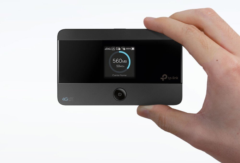 Router TP-LINK M7352 Dłoń trzymająca kciukiem i palcem wskazującym mały, czarny router na białym tle