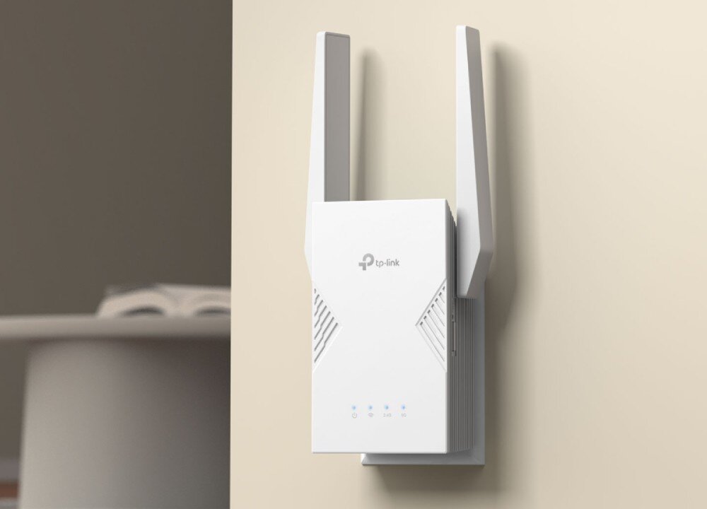 Wzmacniacz sieci TP-LINK RE225BE Biały, pionowy wzmacniacz sygnału z dwiema zewnętrznymi antenami wpięty bezpośrednio do gniazdka elektrycznego na szarej ścianie