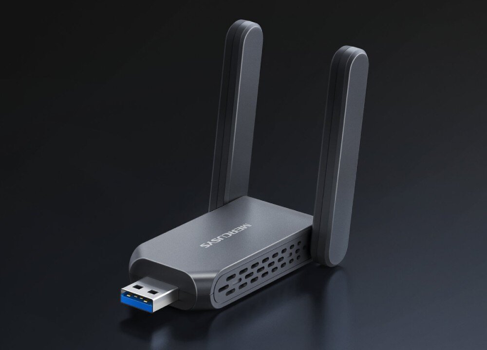 Na ciemnym tle znajduje się karta sieciowa z dwoma antenami i złączem USB-A. Na urządzeniu widoczny jest napis \'MERCUSYS\'.