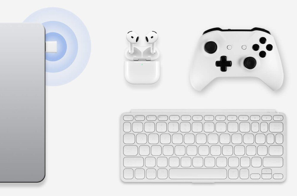 Karta sieciowa MERCUSYS MA60XNB Srebrny laptop z wpiętym białym adapterem emitującym niebieskie fale sygnału otoczony przez białe słuchawki bezprzewodowe biały kontroler do gier oraz białą klawiaturę