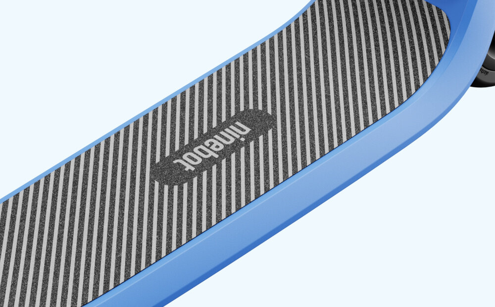 Hulajnoga elektryczna SEGWAY Ninebot C2 Lite 9km 130W 7 cali Czarno-niebieski jasne tło zbliżenie na pokład szeroki pokład pokryty materiałem griptape zwiększa przyczepność stóp zapobiega poślizgom stabilność szeroki podnóżek antypoślizgowe wykończenie bezpieczeństwo młodych użytkowników