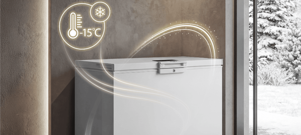 ZAMRAŻARKA WHIRLPOOL W3RHS37EW1 Zdjęcie ukazuje zamrażarkę ustawioną przy przeszklonej ścianie, z zimowym krajobrazem w tle. Obok pojawia się grafika temperatury –15°C i płynny efekt wizualny podkreślający stabilne mrożenie niska temperatura garaż piwnica