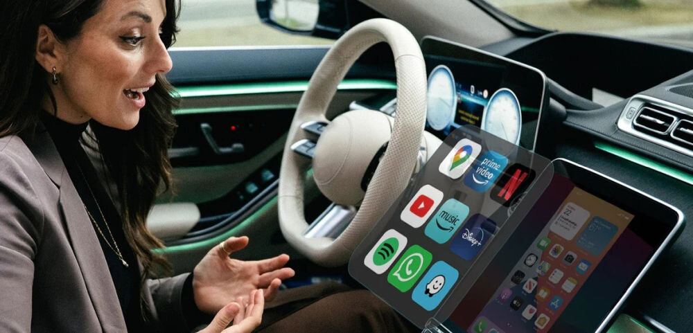 Adapter OTTOCAST CA450-T Mirror Touch CarPlay bezprzewodowe połączenie Apple CarPlay Android Auto automatyczne łączenie smartfona, osoba siedząca w aucie patrząca w wyśwetlacz multimedialny
