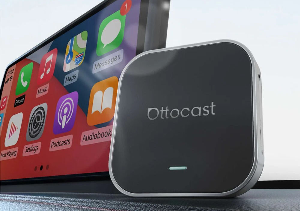 Adapter OTTOCAST PCS55-T OttoAibox E2 CarPlay Android Auto bezprzewodowa integracja smartfona z systemem samochodu, adapter stojący obok radia multimedialnego