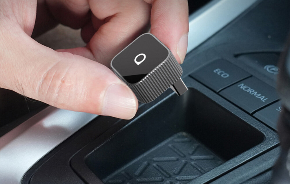 Adapter OTTOCAST CP88-T2 MINI Slim Bluetooth 5.2 połączenie dwa smartfony, osoba trzymająca adapter w ręku