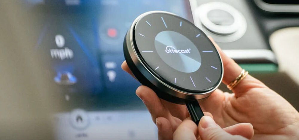 Adapter OTTOCAST PCS46 OttoAibox P3 CarPlay Android Auto bezprzewodowa rozrywka multimedialna w samochodzie, osoba trzymająca adapter w ręku