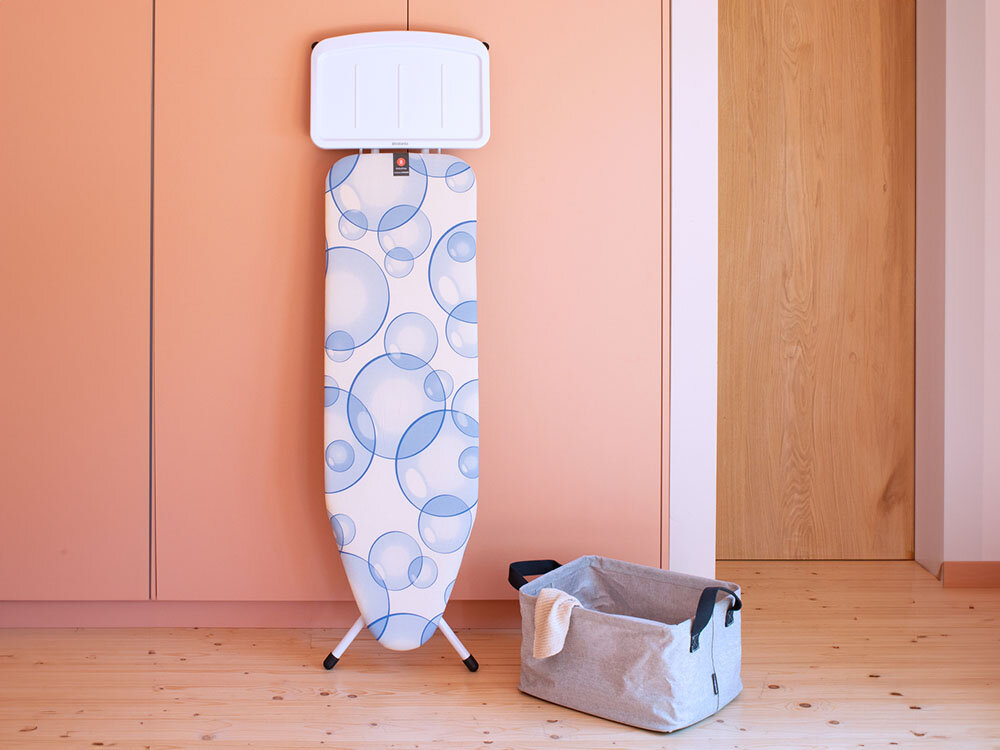 Deska do prasowania BRABANTIA 103629 Bubbles 124 x 38 cm ułatwienie prasowania złożona deska stoi przy ścianie kolorowy pokrowiec jasna podstawa białe nóżki