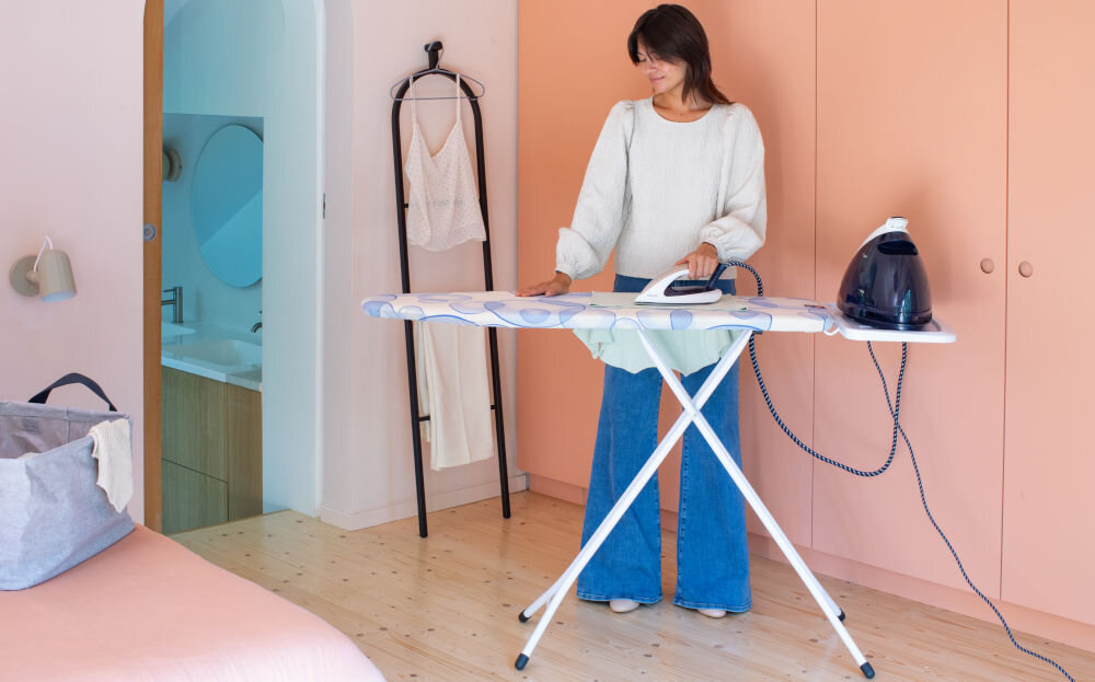 Deska do prasowania BRABANTIA 103629 Bubbles 124 x 38 cm rozłożona deska kolorowy pokrowiec białe nóżki kobieta prasuje generator stoi na podstawce 48 x 7,5 x 160 cm blat 124 x 45 cm  funkcjonalne rozwiązanie solidny uchwyt na generator pary (40 x 22 cm) pokrowiec z bawełny przylegająca osłona z zapięciem na sznurek system napięcia Stretch-System wygoda, bezpieczeństwo i jakość współczesne gospodarstwo domowe 