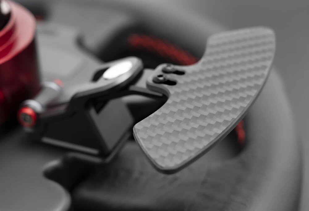 Kierownica SIMAGIC GT Sport 300mm QR50 Alcantara Detal tylnej łopatki zmiany biegów o strukturze plecionki włókna węglowego, zamontowanej na metalowym ramieniu przy kierownicy