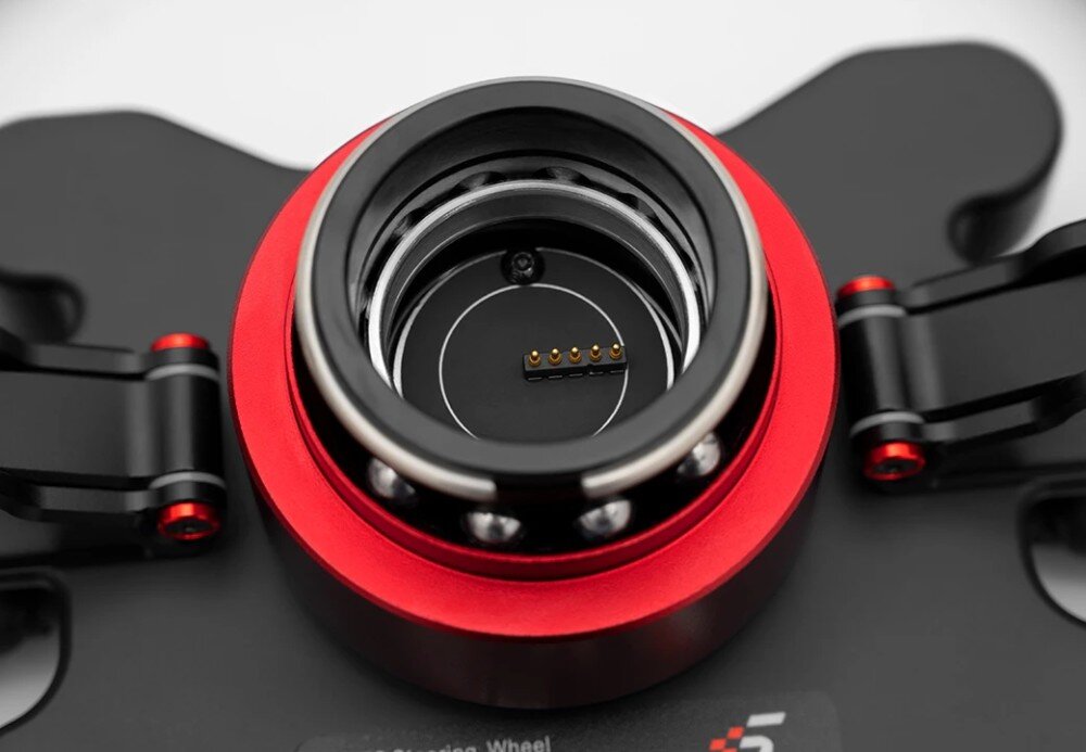 Kierownica SIMAGIC GT Sport 300mm QR50 Alcantara Zbliżenie na wnętrze metalowego mechanizmu szybkiego montażu kierownicy z widocznymi kulkami łożyskowymi i pięcioma złotymi pinami styków