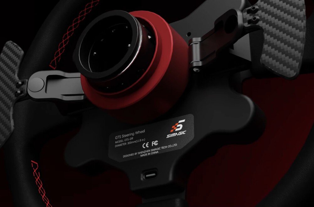 Kierownica SIMAGIC GT Sport 300mm QR50 Alcantara Tył okrągłej kierownicy wyścigowej z widocznym centralnym mechanizmem szybkiego montażu, łopatkami z włókna węglowego i naklejką znamionową