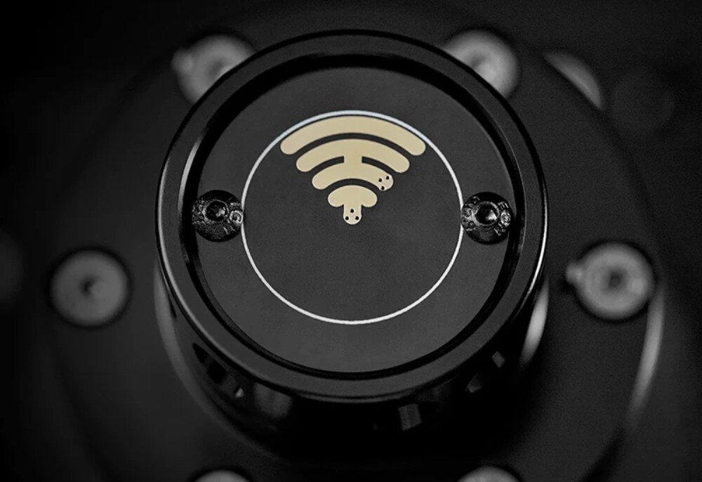 Baza kierownicy SIMAGIC Alpha 15 Nm Direct Drive S102 Widok z góry na okrągły element szybkozłącza z symbolem fal bezprzewodowych pośrodku i dwiema śrubami po bokach