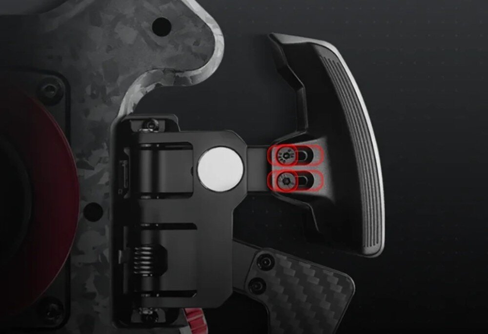 Obraz przedstawia fragment mechanizmu z elementami metalowymi i plastikowymi, w tym uchwyt z dwoma śrubami zaznaczonymi na czerwono. Tło jest ciemne, a niektóre części mają teksturę przypominającą włókno węglowe.