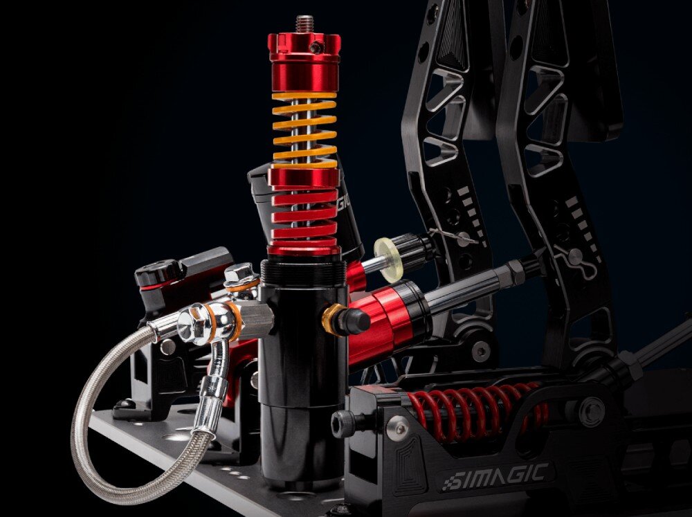 System hydrauliczny z trzema pedałami SIMAGIC S309 Zbliżenie na mechanizm hydrauliczny pedału z widocznym cylindrem, pionową sprężyną i elastycznym przewodem w stalowym oplocie