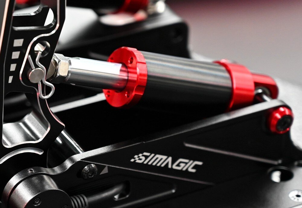 System z trzema pedałami SIMAGIC S303 Bliskie ujęcie metalowego cylindra mechanicznego z ruchomym tłokiem zamontowanego przy ramieniu jednego z pedałów wyścigowych symulatora