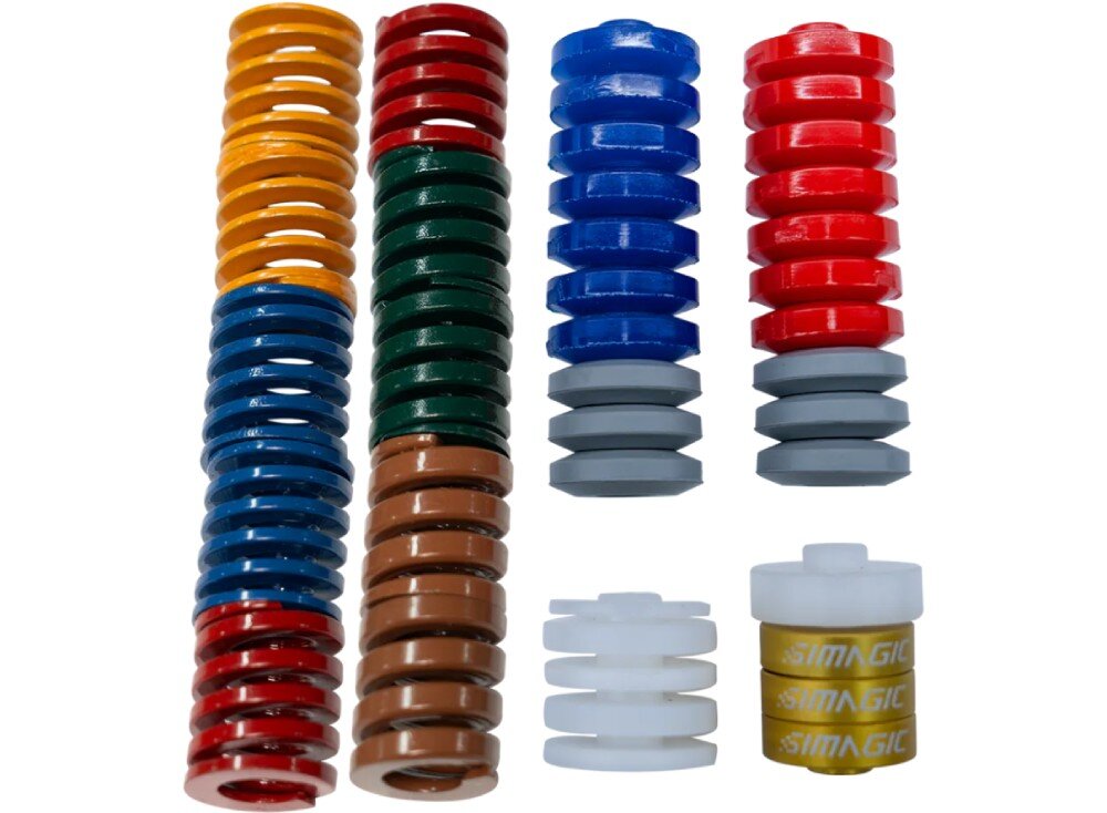 Podkładki gumowe i sprężyny SIMAGIC S441 Dwa długie rzędy sprężyn, dwa krótsze rzędy elastomerów, biały plastikowy element oraz ułożone na sobie krążki z napisem SIMAGIC na białym tle