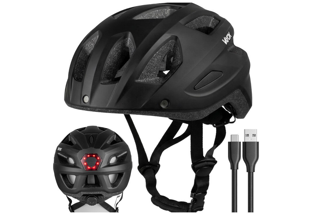 Czarny kask rowerowy z otworami wentylacyjnymi i lampką z tyłu. Obok kasku widoczny jest kabel USB z dwoma różnymi końcówkami.
