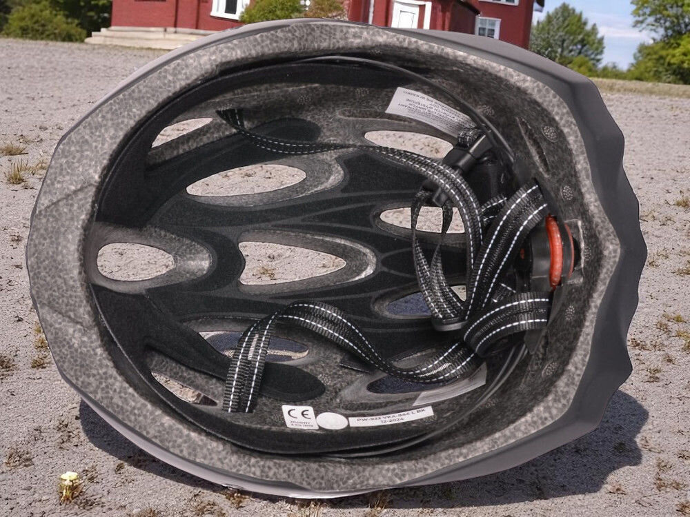 Kask rowerowy VÖGEL VKA-944 Czarny MTB kask leżący na boku widoczny środek kasku regulacja paski pełne dopasowanie regulacja od 55 do 58 cm