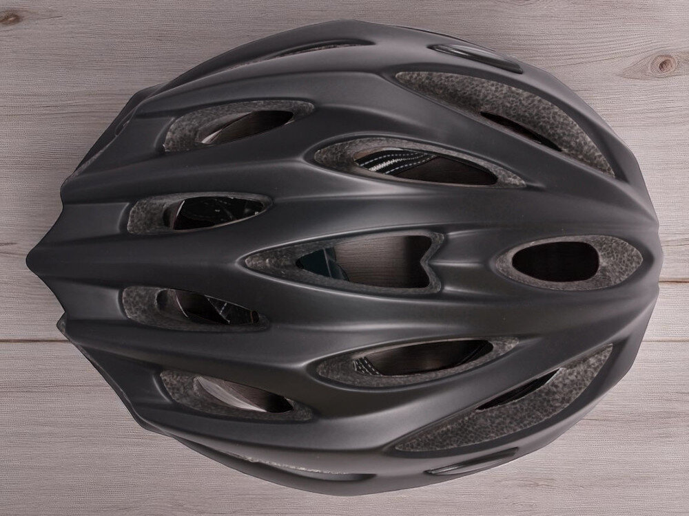 Kask rowerowy VÖGEL VKA-944 Czarny MTB widok z góry na kask na drewnianym blacie 23 otwory wentylacyjne chłód komfort bez przegrzania