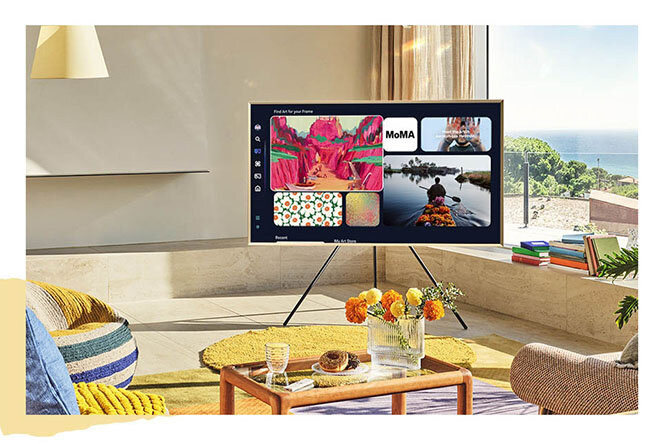 Tryb Sztuka włączony na telewizorze Samsung The Frame (2025) ustawiony na nóżkach w pokoju z widokiem na morze
