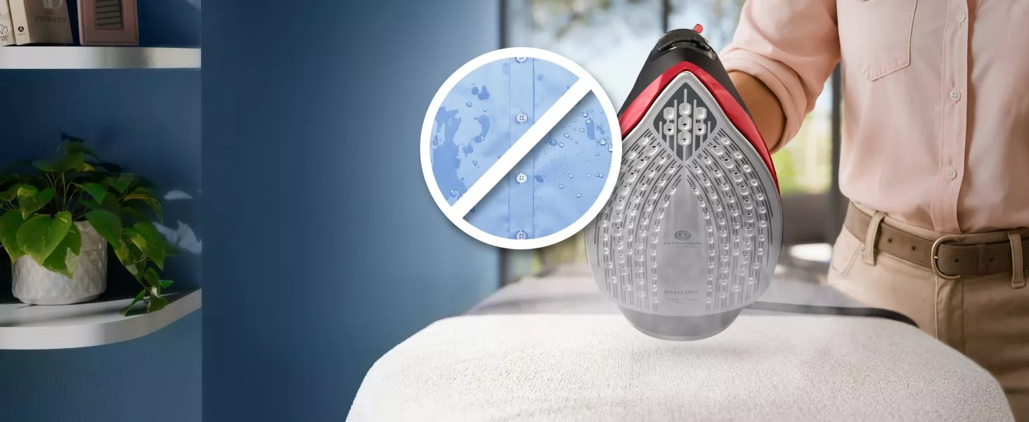 Osoba prasuje tkaninę żelazkiem z widoczną stopą żelazka, na której znajduje się logo PHILIPS. Obok znajduje się symbol przekreślonej mokrej koszuli, sugerujący funkcję zapobiegającą powstawaniu plam wodnych.